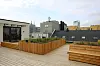 Takterrasse med trekasser, beplantning og utsikt mot byblokker